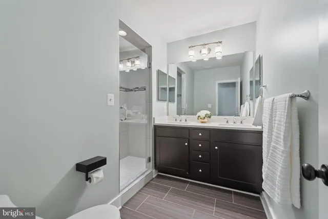 a bathroom with a sink mirror and a shower