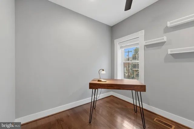 a view of a workspace with furniture and wooden floor