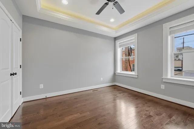 a view of an empty room with a window and wooden floor