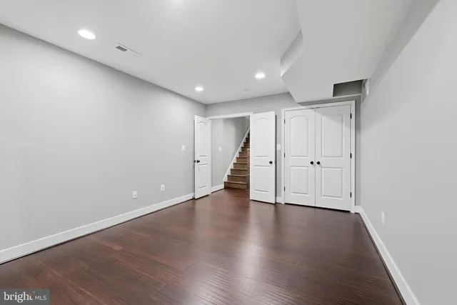 a view of an empty room with wooden floor and entryway