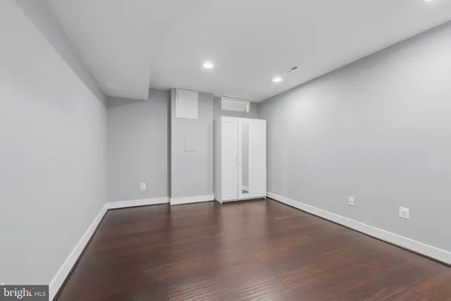 a view of an empty room with wooden floor