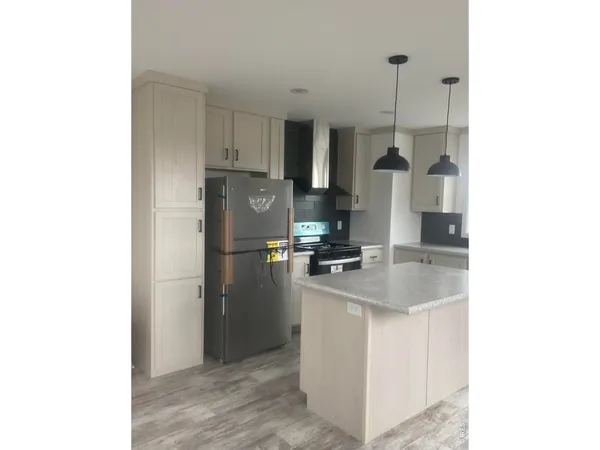 a kitchen with stainless steel appliances granite countertop a sink a refrigerator and a stove