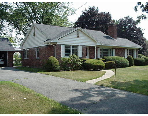 a front view of a house with a yard and potted plants
