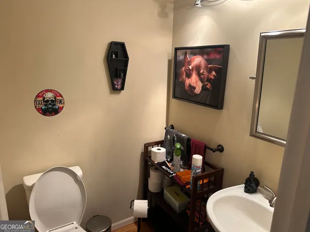 a bathroom with a toilet a sink and mirror