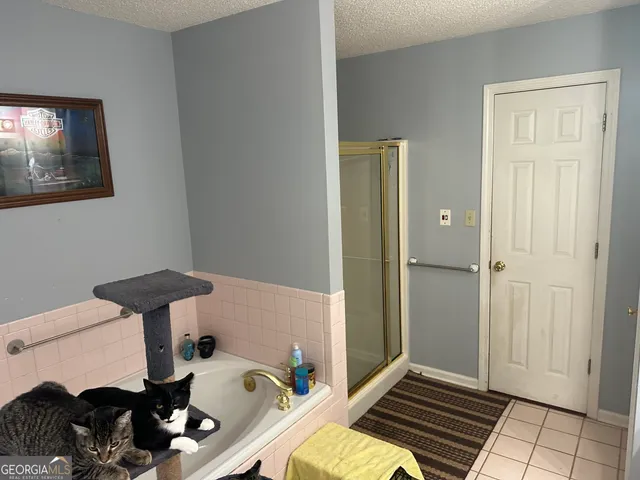 a bedroom with a bed and a lamp on dresser