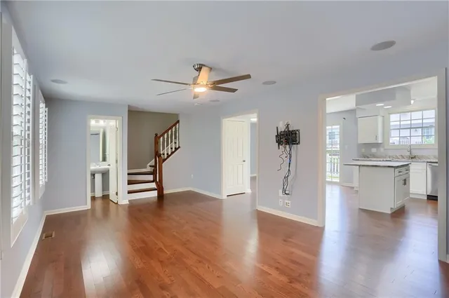 a view of an empty room with a kitchen and wooden floor