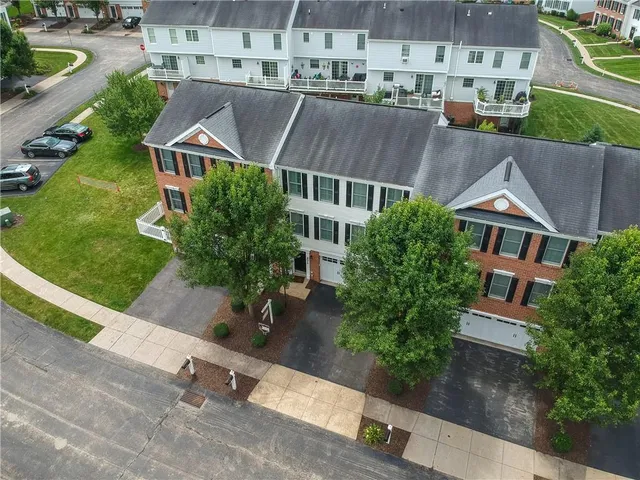 an aerial view of multiple houses with a yard