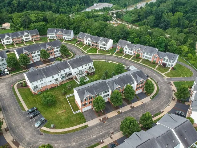 an aerial view of a house with a garden and lake view