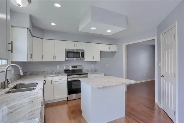 a kitchen with stainless steel appliances granite countertop a sink stove and refrigerator