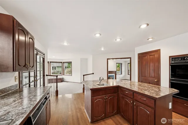 a kitchen with stainless steel appliances granite countertop a sink stove and cabinets