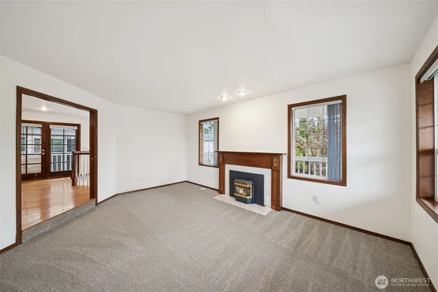 an empty room with windows fire place and fireplace