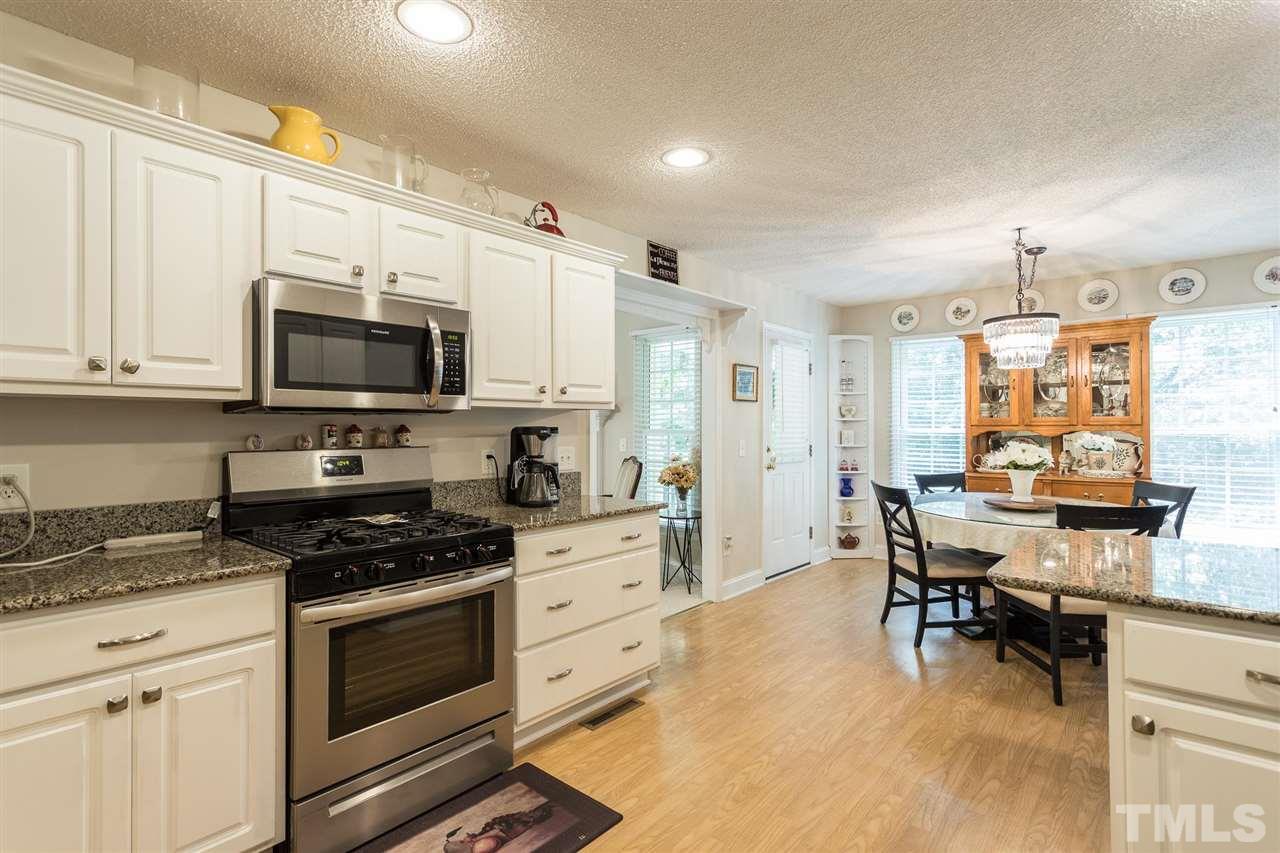51 Hunters Lane Timberlake, NC 27583 - Photo 12 of 30 a kitchen with granite countertop a stove and white cabinets