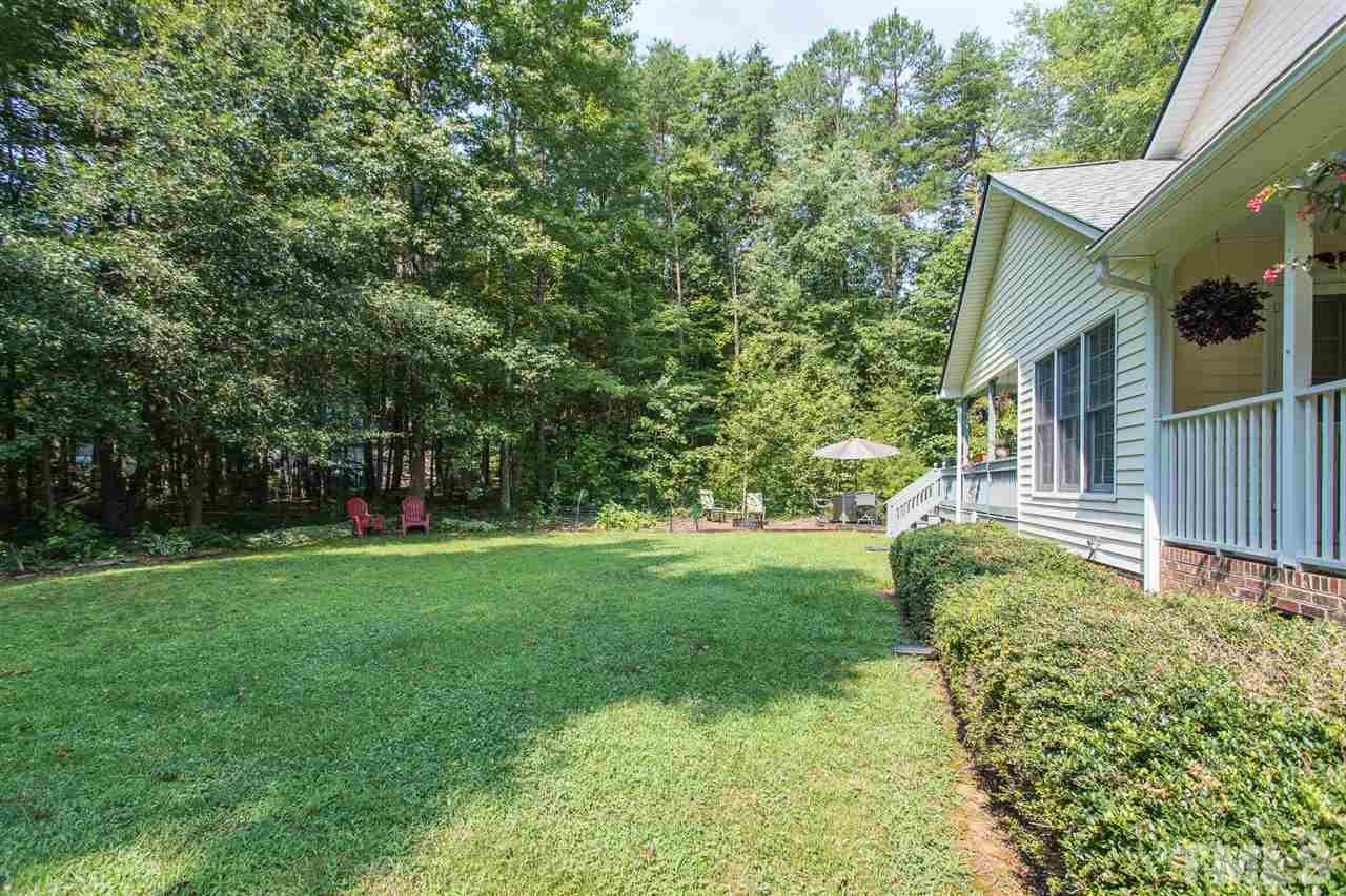 51 Hunters Lane Timberlake, NC 27583 - Photo 28 of 30 a backyard of a house with plants and large trees