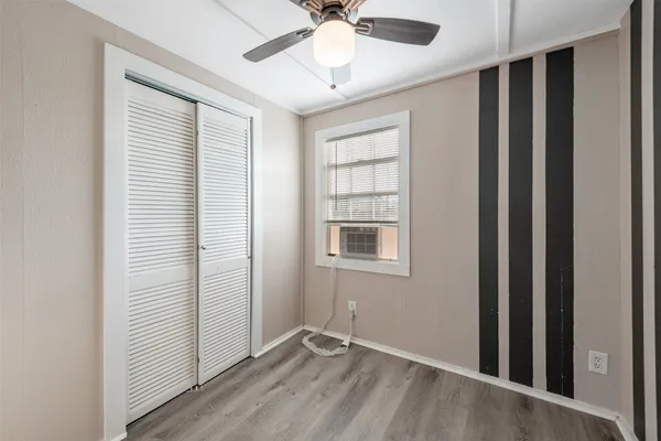 an empty room with windows and fan