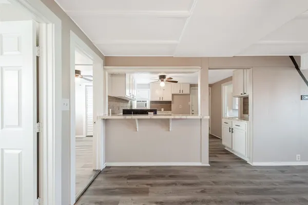 a view of a kitchen with a refrigerator and wooden floor