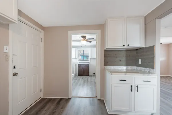 a view of a kitchen with wooden floor and electronic appliances
