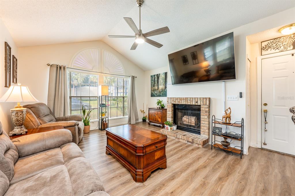 954 Forest Ridge Court, Unit 106 Lake Mary, FL 32746 - Photo 3 of 20 a living room with furniture a flat screen tv and a fireplace