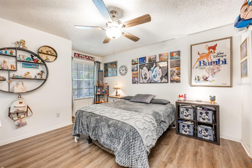 954 Forest Ridge Court, Unit 106 Lake Mary, FL 32746 - Photo 10 of 20 a bedroom with a bed and a table with wooden floor