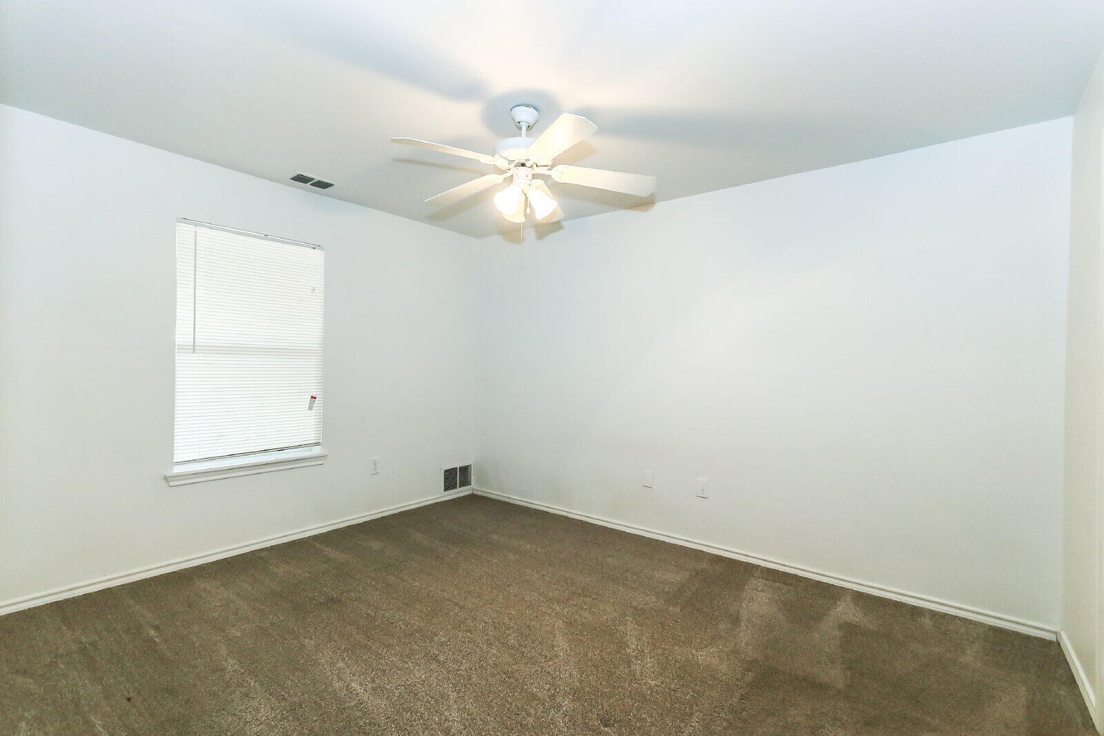 606 North Englewood Avenue, Unit A Lubbock, TX 79416 - Photo 12 of 19 an empty room with a window and a fan