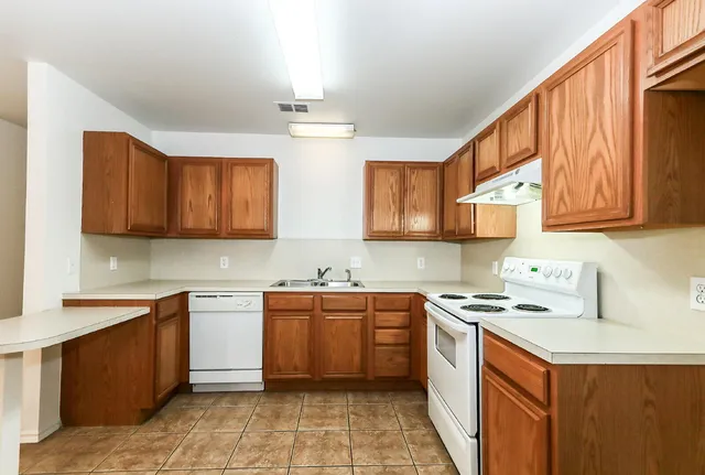 a kitchen with stainless steel appliances a sink stove and cabinets