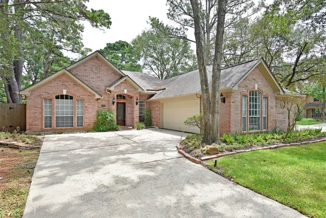 a front view of a house with a garden and trees