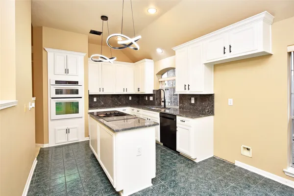 a kitchen with a sink and a stove top oven