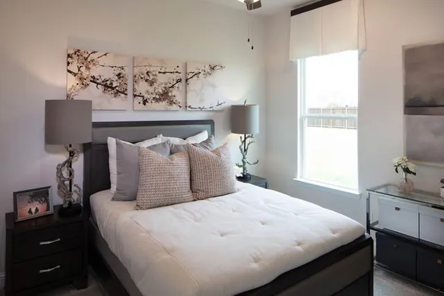 a large bed sitting in a bedroom next to a window