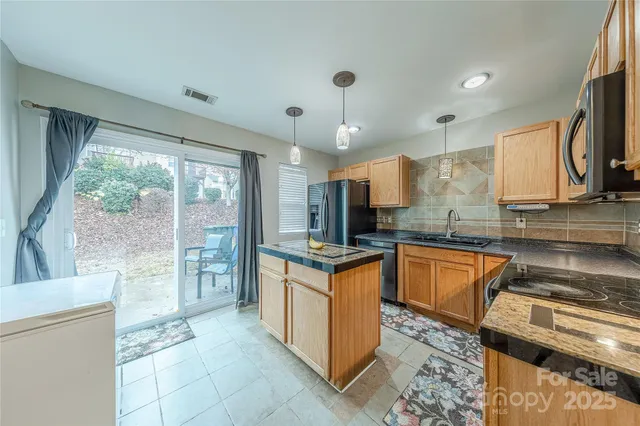 a kitchen with stainless steel appliances granite countertop a stove a sink and a refrigerator