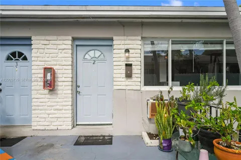 a front view of a house with a potted plant