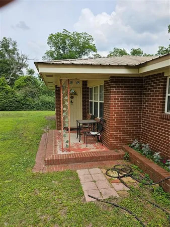 a view of a patio with table and chairs potted plants and floor to ceiling window