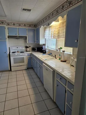 a kitchen with a sink a stove a microwave and cabinets