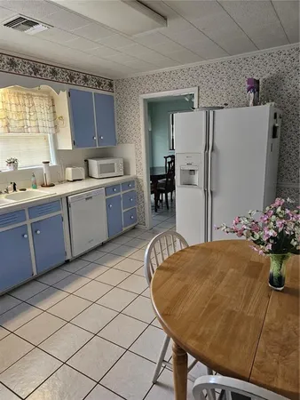 a kitchen with a table chairs sink and refrigerator