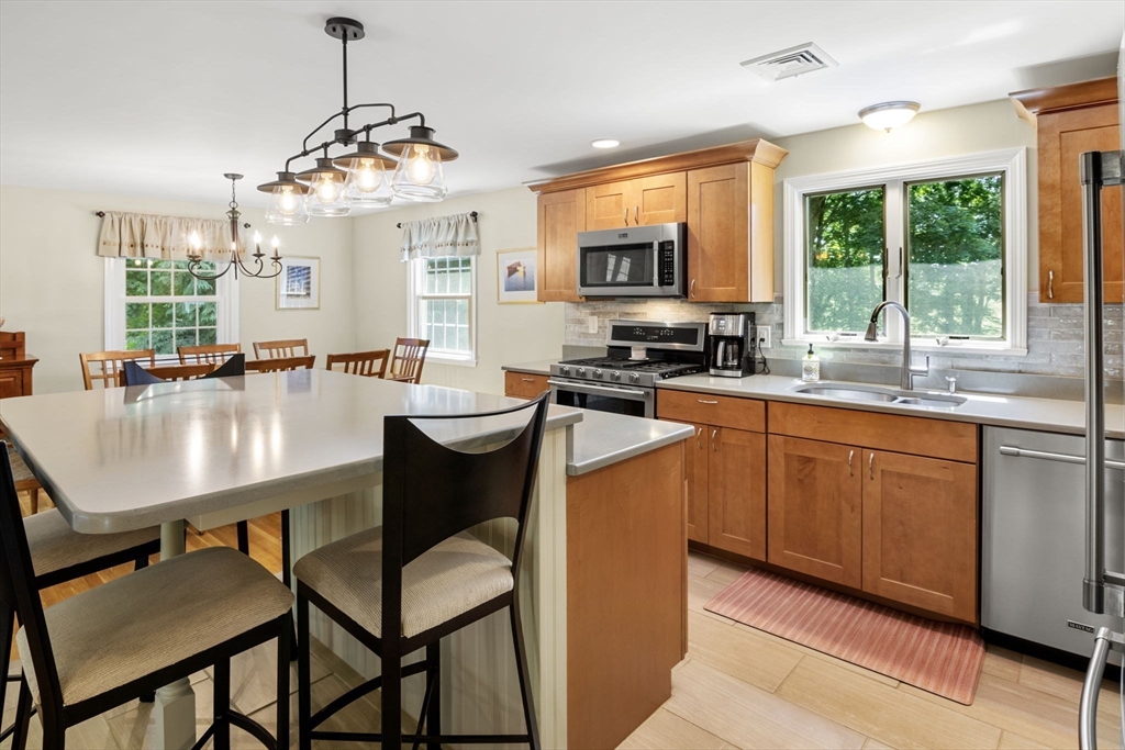 13 Spring Street Danvers, MA 01923 - Photo 12 of 39 a kitchen with granite countertop a stove a sink a dining table and chairs