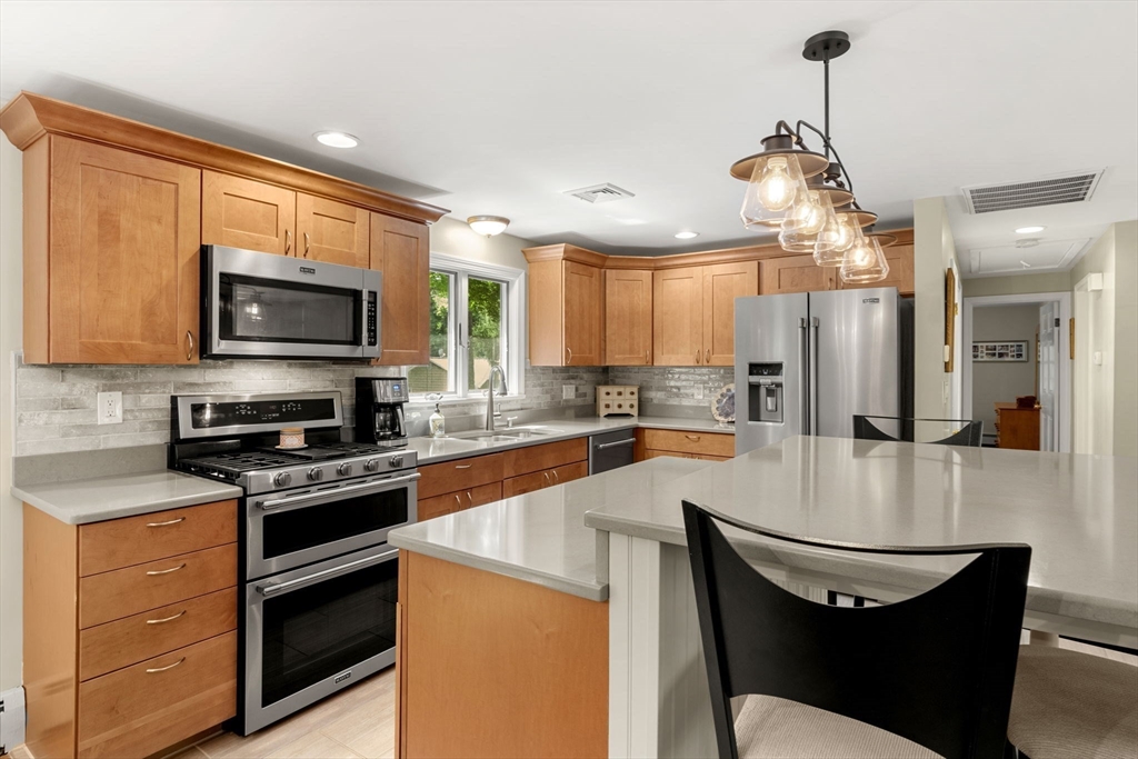 13 Spring Street Danvers, MA 01923 - Photo 13 of 39 a kitchen with stainless steel appliances granite countertop a stove a sink and a microwave
