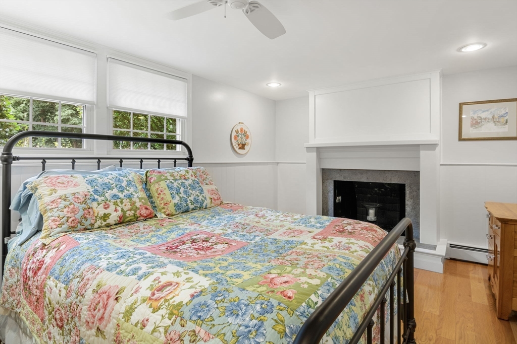 13 Spring Street Danvers, MA 01923 - Photo 24 of 39 a bedroom with a large bed and a fireplace