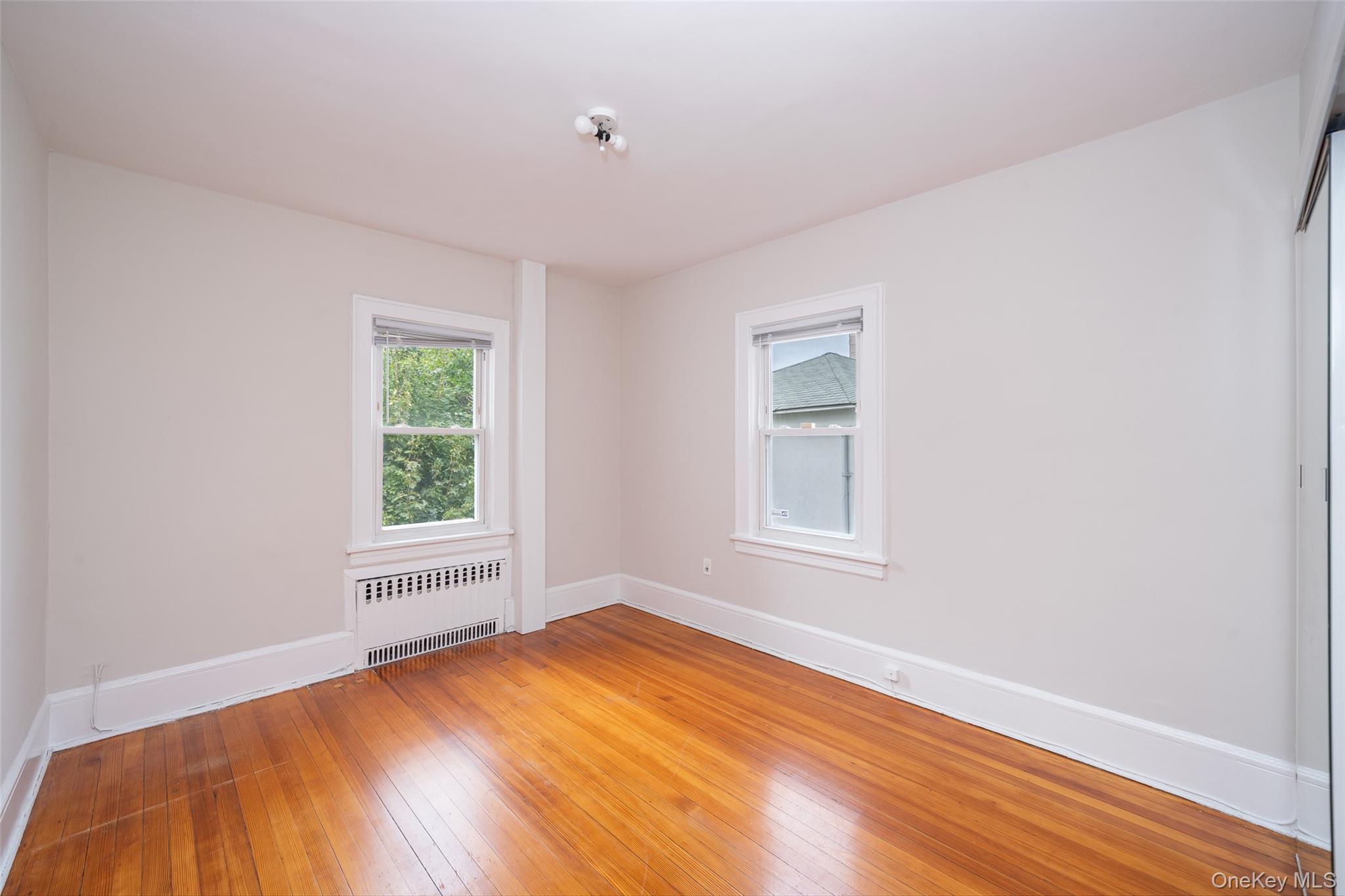45 Chestnut Street Tuckahoe, NY 10707 - Photo 12 of 27 Spare room featuring radiator heating unit and hardwood / wood-style flooring