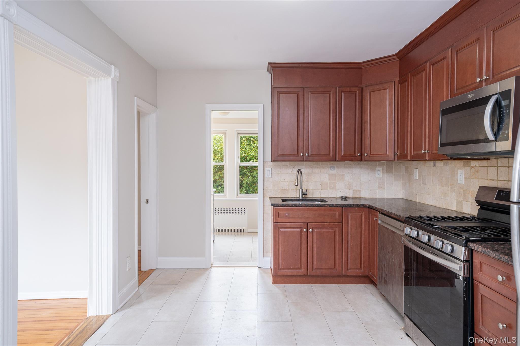 45 Chestnut Street Tuckahoe, NY 10707 - Photo 6 of 27 Kitchen with stainless steel appliances, dark stone countertops, tasteful backsplash, and radiator heating unit