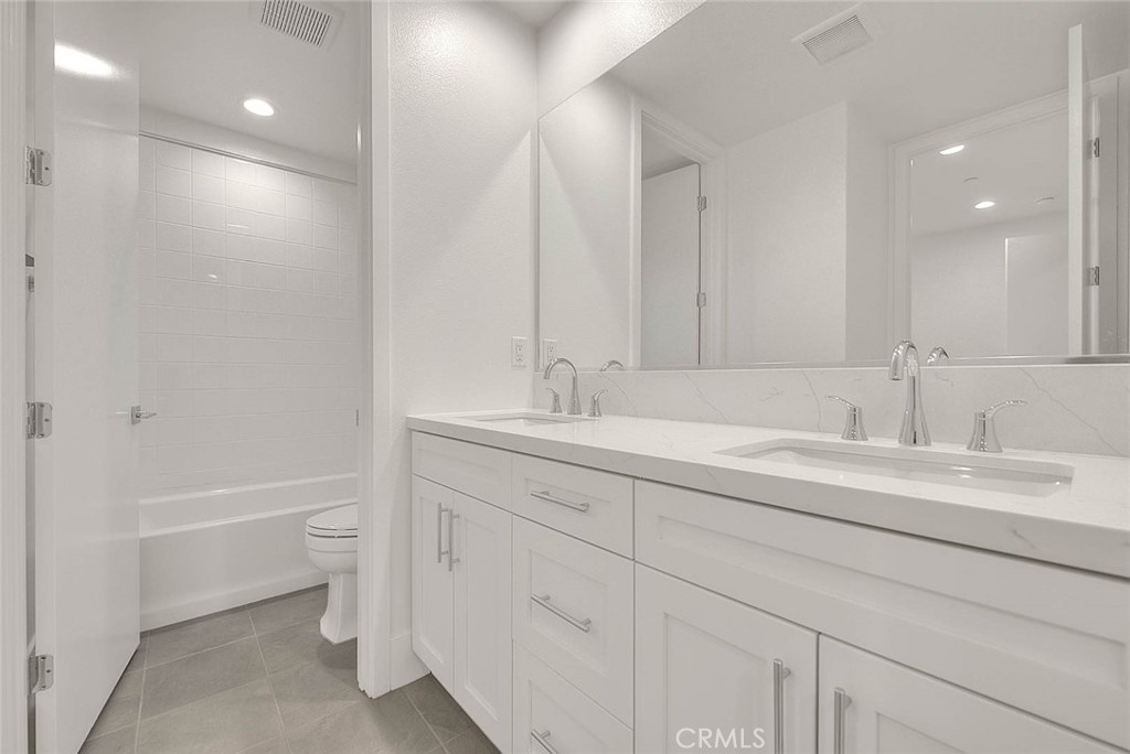 28 Remy Lane Montebello, CA 90640 - Photo 29 of 68 a bathroom with a double vanity sink a mirror and a bathtub