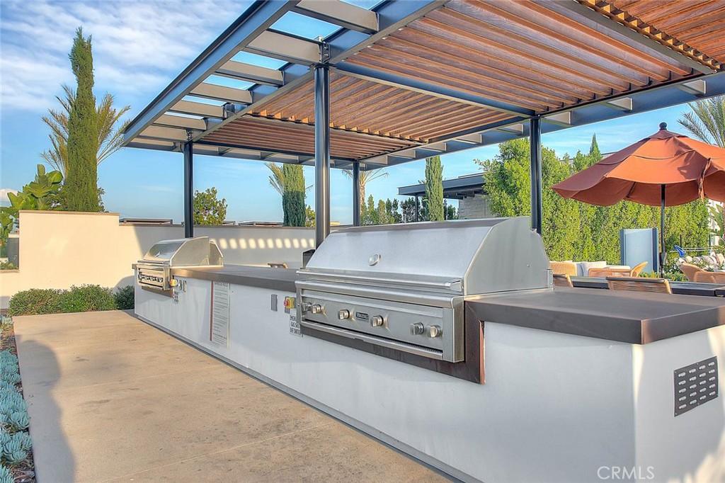 28 Remy Lane Montebello, CA 90640 - Photo 66 of 68 a view of outdoor kitchen with a table and chairs under an umbrella