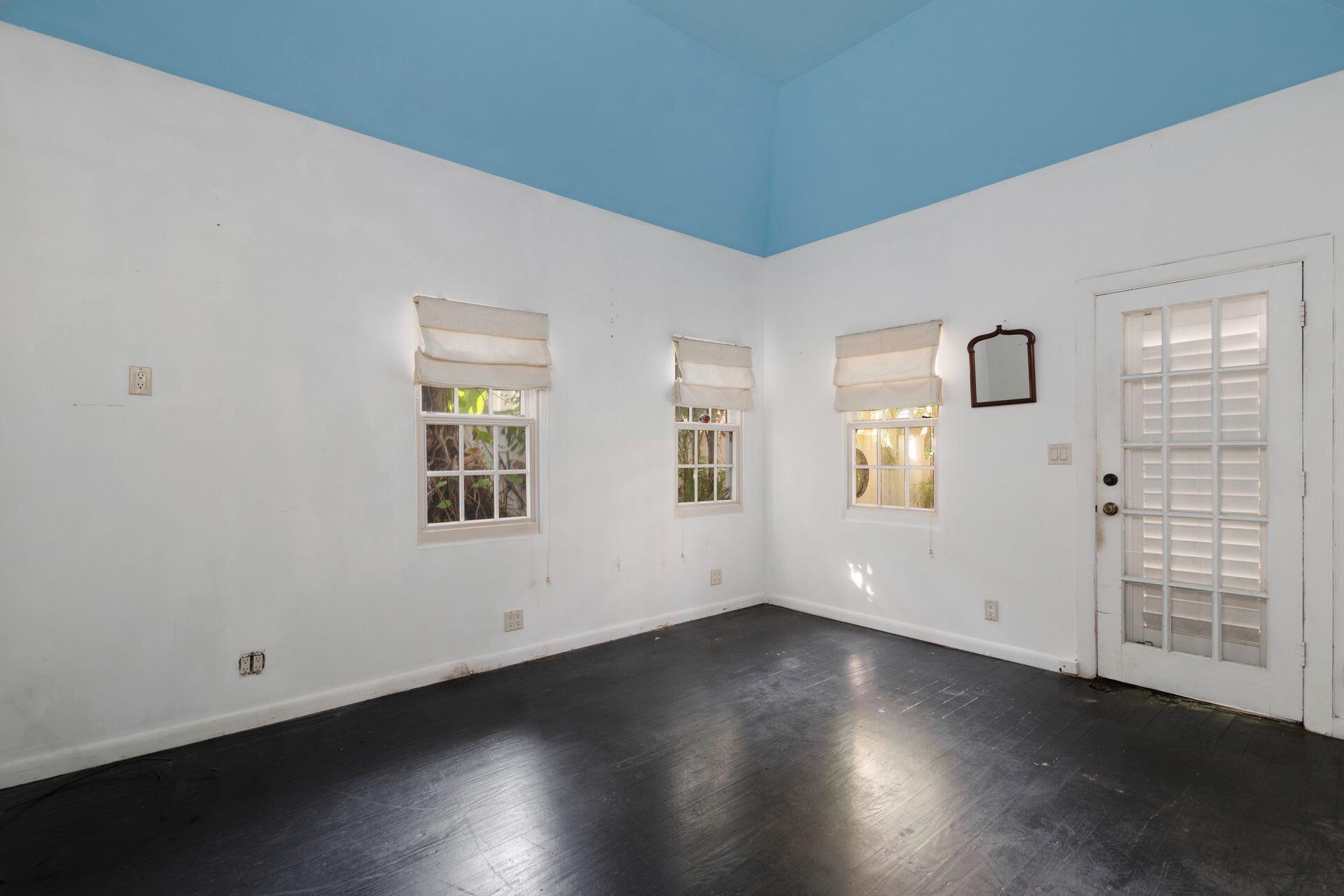 228 Phipps Plaza Palm Beach, FL 33480 - Photo 14 of 24 an empty room with wooden floor and windows