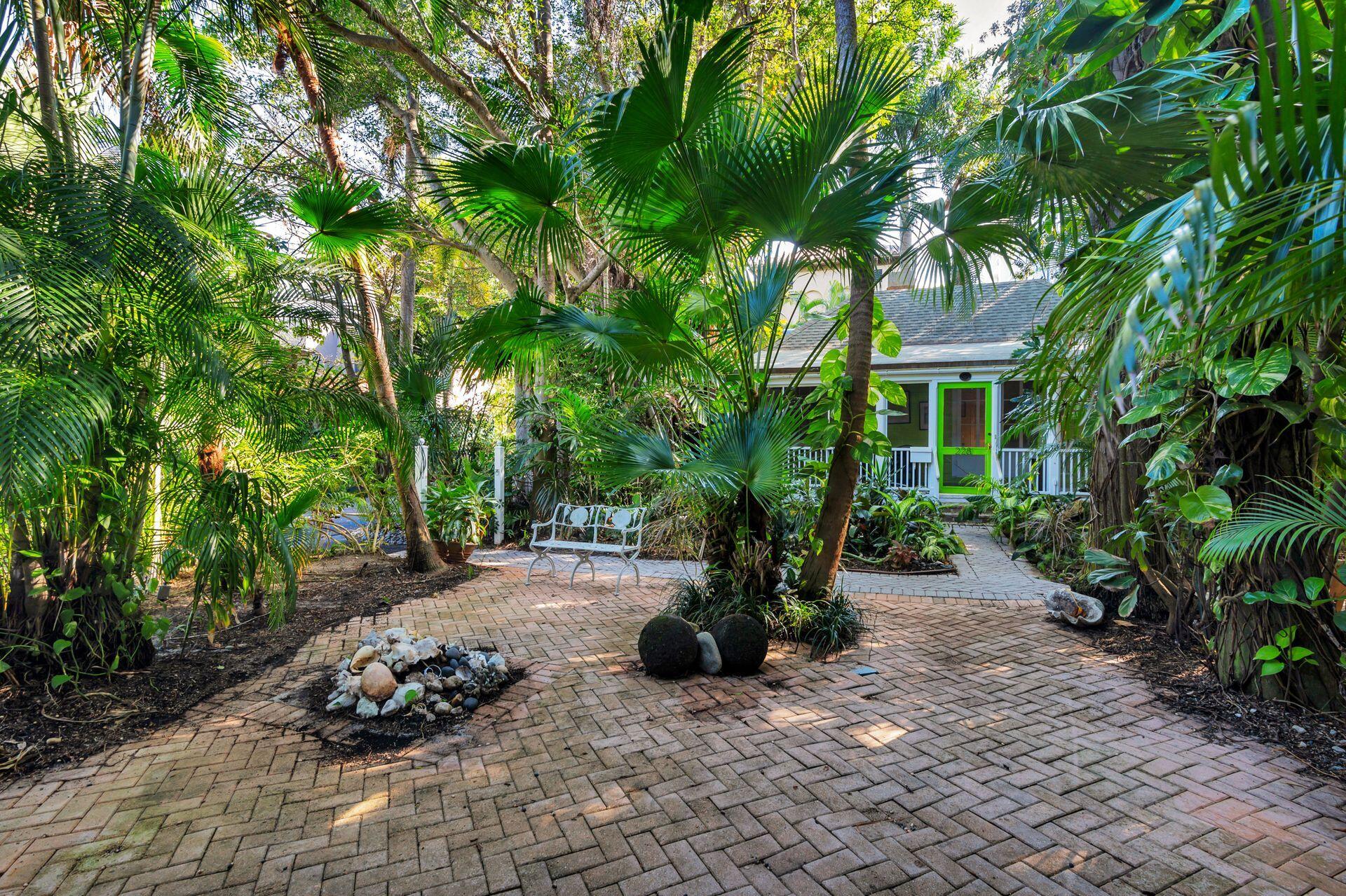 228 Phipps Plaza Palm Beach, FL 33480 - Photo 22 of 24 a view of a chair and tables in the garden