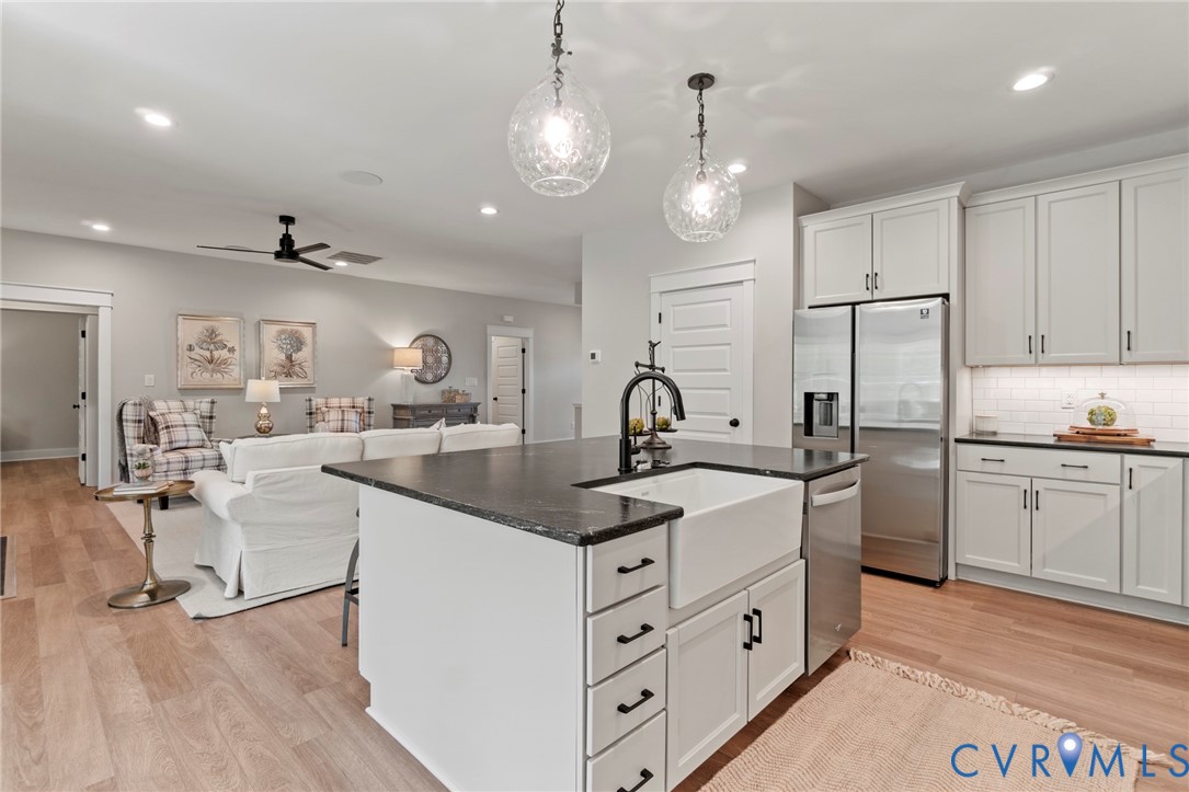Kitchen island with a farmhouse sink and dark coun