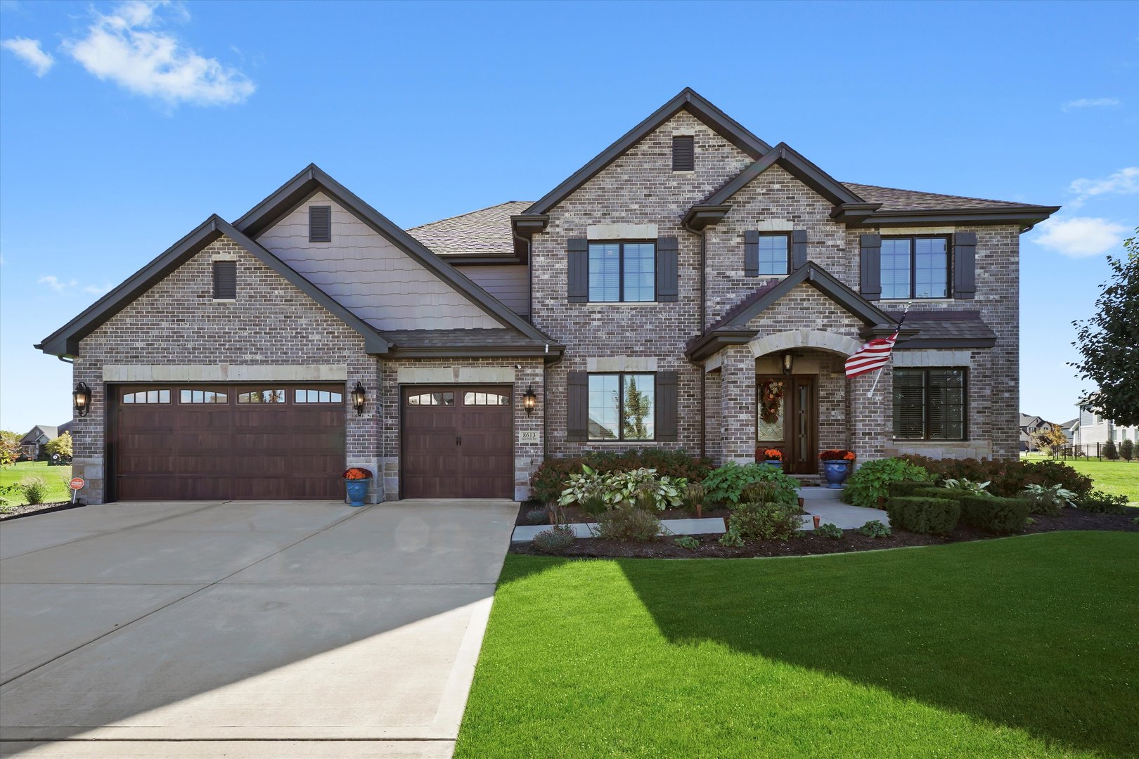 a front view of a house with a garden and plants