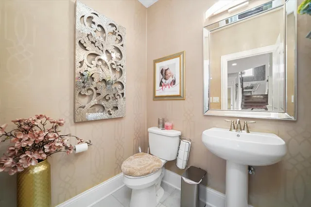 a bathroom with a sink mirror and toilet