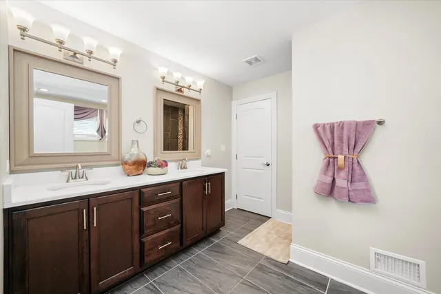 a spacious bathroom with a double vanity sink and a mirror