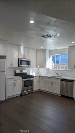 a large kitchen with a stove top oven and white cabinets