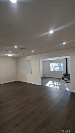 a view of empty room with wooden floor and windows