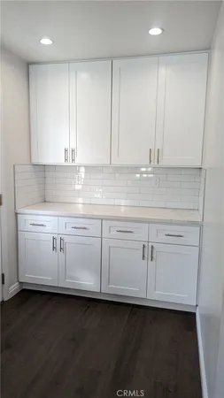 a kitchen with white cabinets and sink