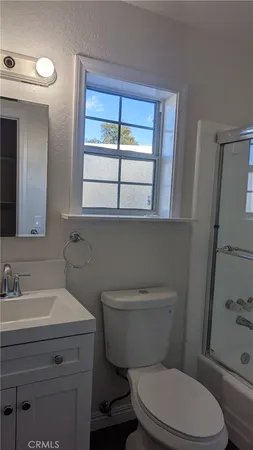 a bathroom with a toilet a sink a vanity and mirror