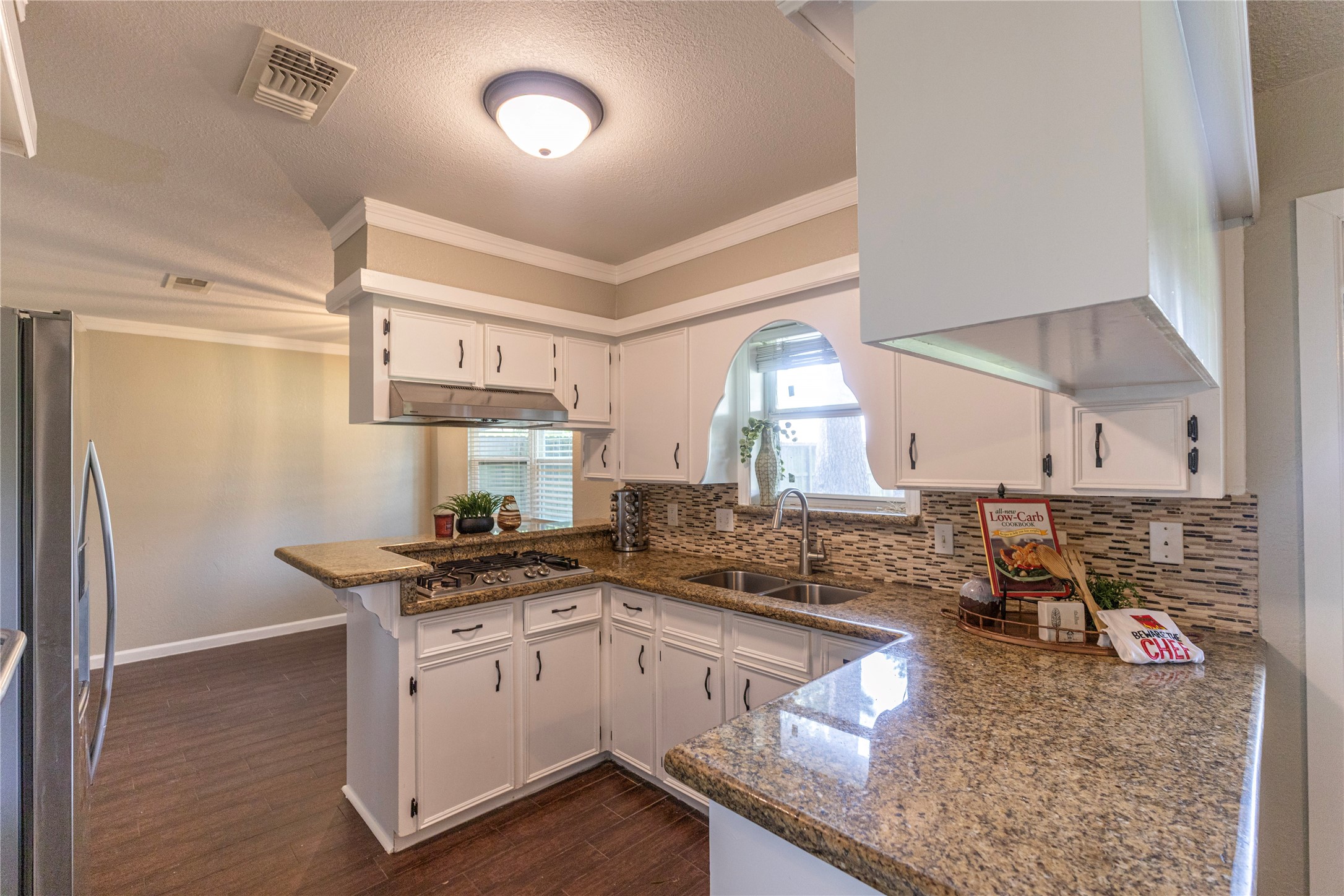 14419 Wadebridge Way Houston, TX 77015 - Photo 6 of 20 This kitchen features a gas stove! The space has a cozy, modern feel with wood flooring and a neutral color palette.
